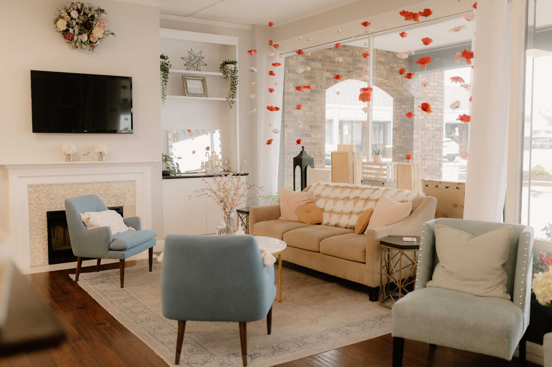 Cozy living room with modern decor, blue chairs, and a floral accent wall.